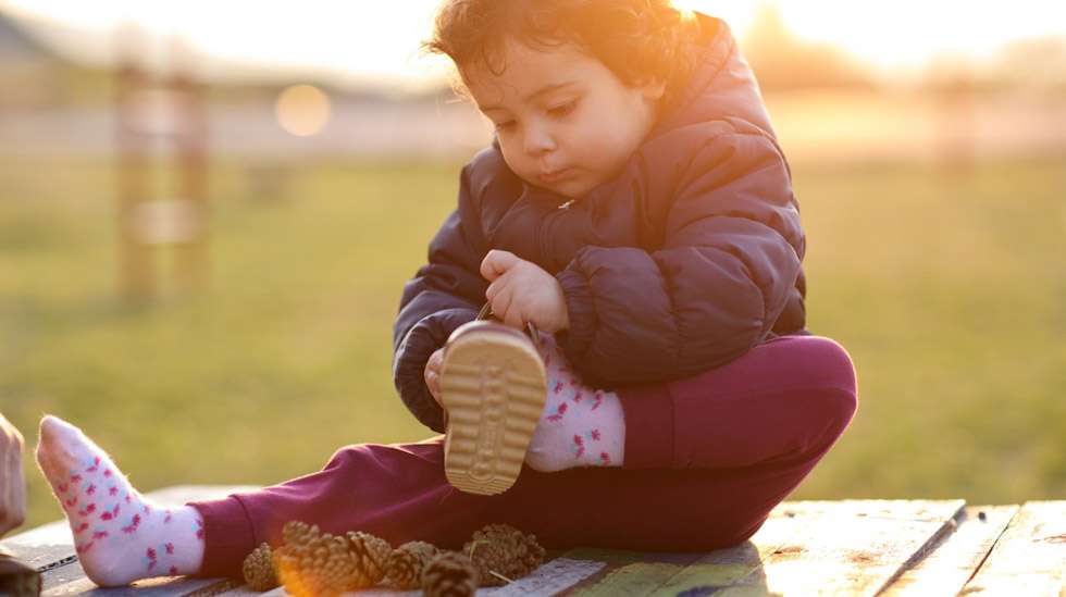 Lapsi osaa jo pukea ainakin osan vaatteistaan. Kenkien pukeminen voi olla vielä haastavaa. Kuva: iStock