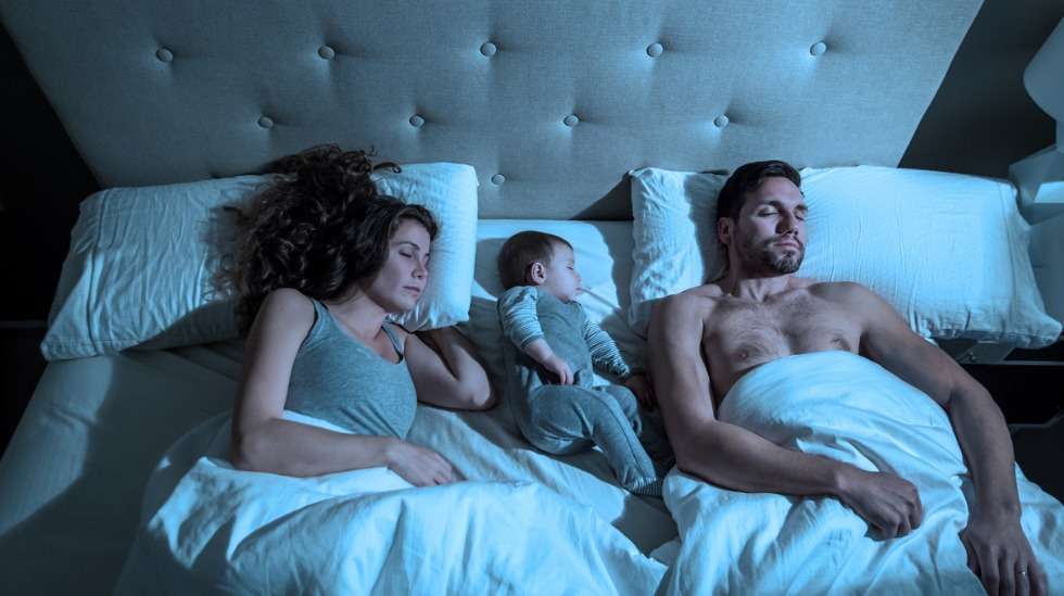 Vanhempien kanssa samassa sängyssä nukkuminen nostaa kätkytkuoleman riskiä hieman, mutta suurempi yksittäinen tekijä on vauvan nukkumisasento. Nukuta vauva aina selällään. Kuva: iStock