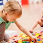 toddler-girls-playing-with-puzzle-pieces-in-a-preschool-classroom-picture-id598560056
