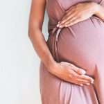 pregnant-woman-in-dress-holds-hands-on-belly-on-a-white-background-picture-id835757738