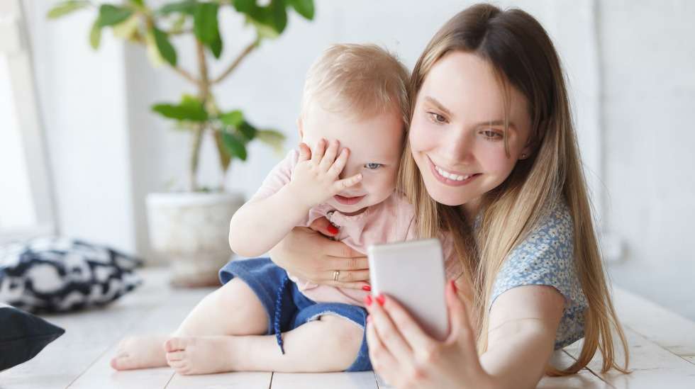 Laskeudu puhelimen kanssa lapsen tasolle, sanoita lapselle mitä puhelun aikana tapahtuu ja hyväksy se, että lapsi poistuu välillä touhuilemaan omiaan. Kuva: iStock