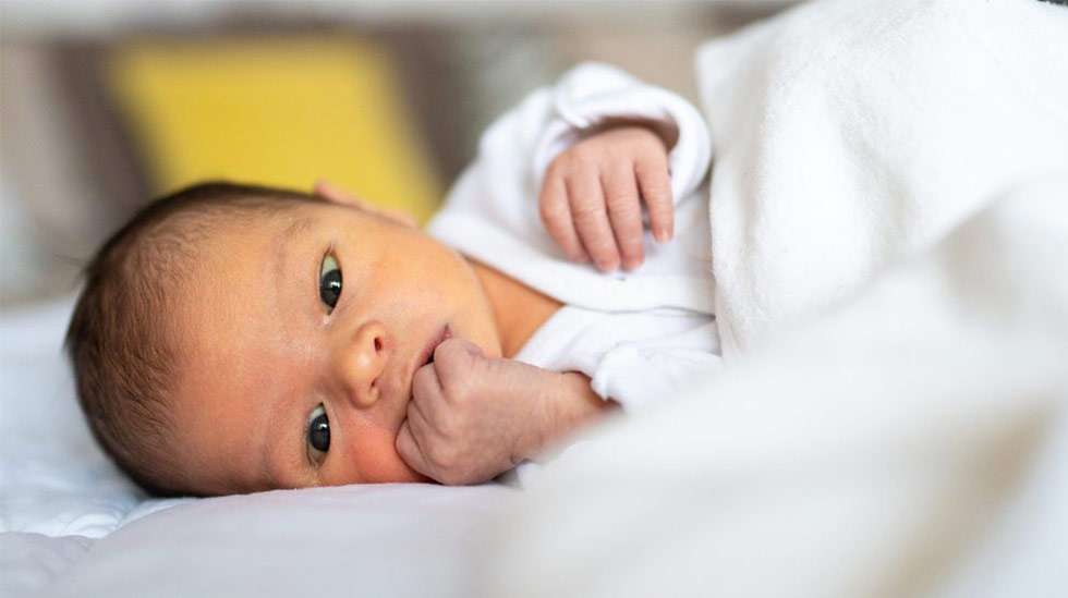 Nyrkkien imeskely on yksi pienen vauvan varhaisista nälkäviesteistä. Kuva: iStock
