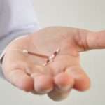 holding-an-iud-birth-control-device-in-hand-picture-id482344087
