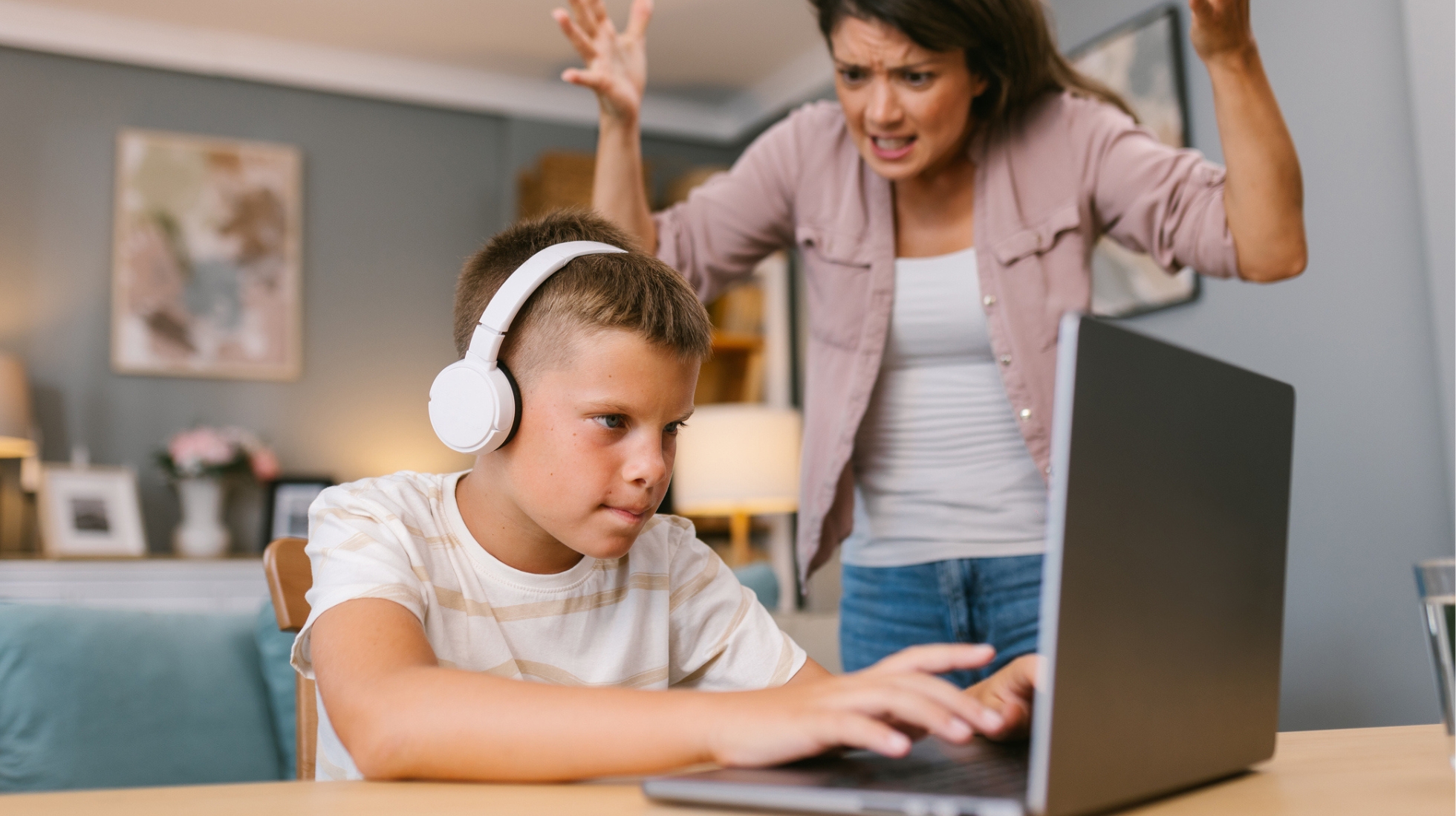 Turhautunut äiti huutaa tietokonetta pelaavalle lapselle