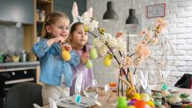 Hauskaa tekemistä lasten kanssa – 10 vinkkiä pääsiäislomalle Kaksi tyttölasta keittiössä asettelemassa pääsiäiskoristeita