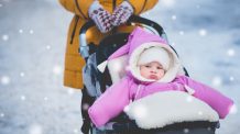 Vauva ulkona lastenvaunuissa puettuna talvivaatteisiin